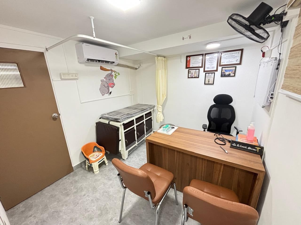 Dr. Lokesh Sharma's consulting room, with an examination couch and a child-sized chair