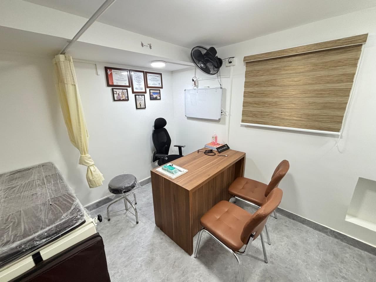 A consulting room with examination couch, privacy curtain and natural light